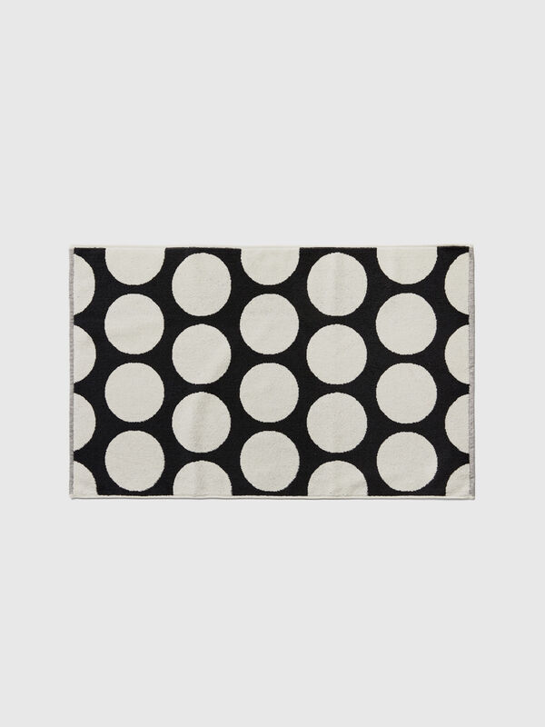 Black bathroom rug with white polka dots
